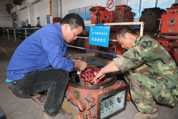 機(jī)電車間電修工徐庭軍和徒弟正在檢修開關(guān)
