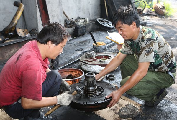 選運(yùn)區(qū)維修班班長(zhǎng)路續(xù)軒和工友對(duì)推土機(jī)變速箱部件進(jìn)行整形